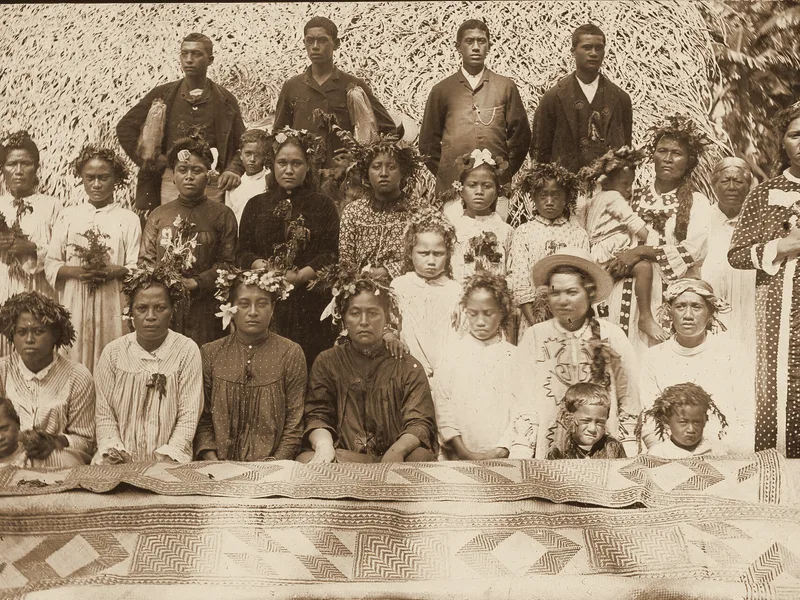Cook Islanders with a woven mat, Ngatangiia, Rarotonga, about 1900. Public domain.